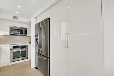 a metallic refrigerator freezer a stove sitting inside of a kitchen