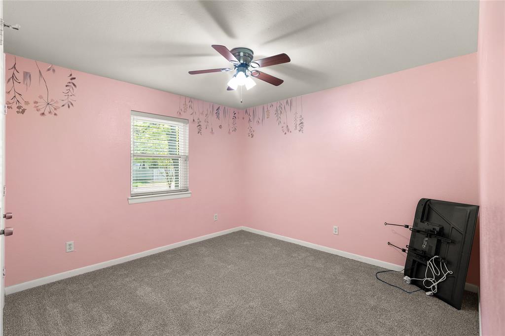 1109 Pine Ridge Drive Azle, TX 76020 - Photo 16 of 24 This room features a window with blinds, grey carpet, and a ceiling fan with a light fixture