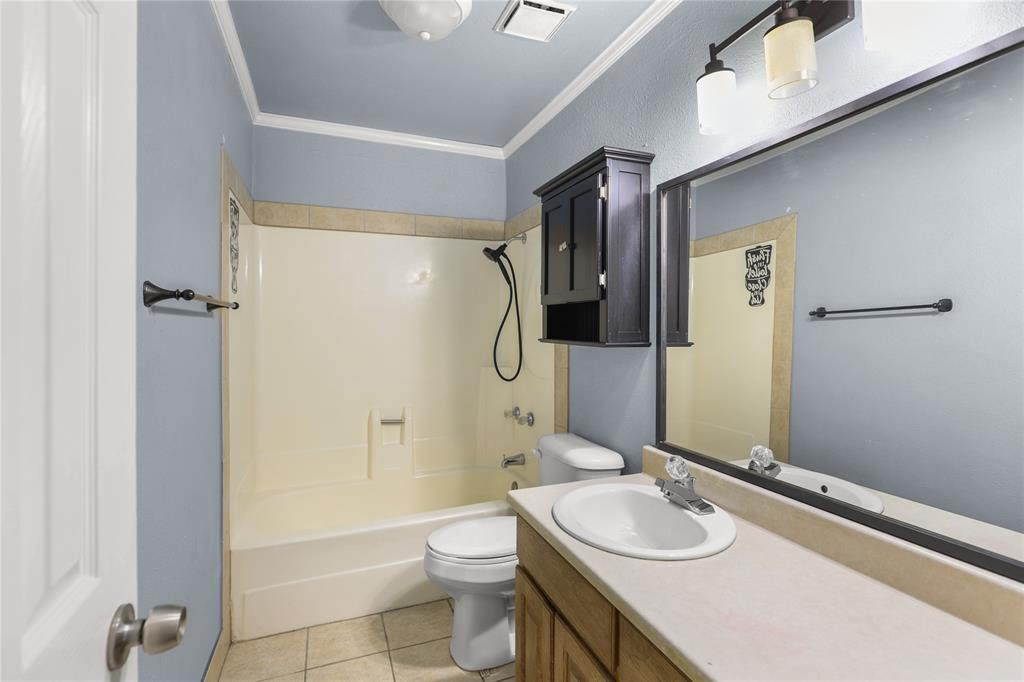 1109 Pine Ridge Drive Azle, TX 76020 - Photo 17 of 24 Bathroom featuring a shower and bathtub combination, a vanity with a white sink, and a large wall-mounted mirror