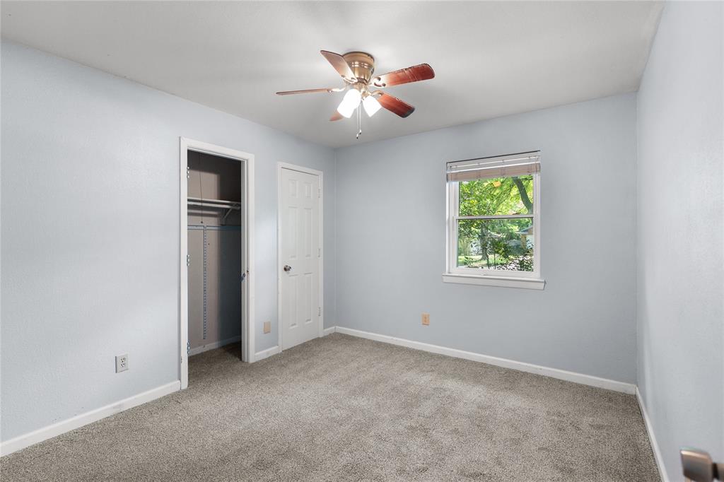 1109 Pine Ridge Drive Azle, TX 76020 - Photo 18 of 24 This room features light blue walls, gray carpet, a ceiling fan, and a window providing natural light