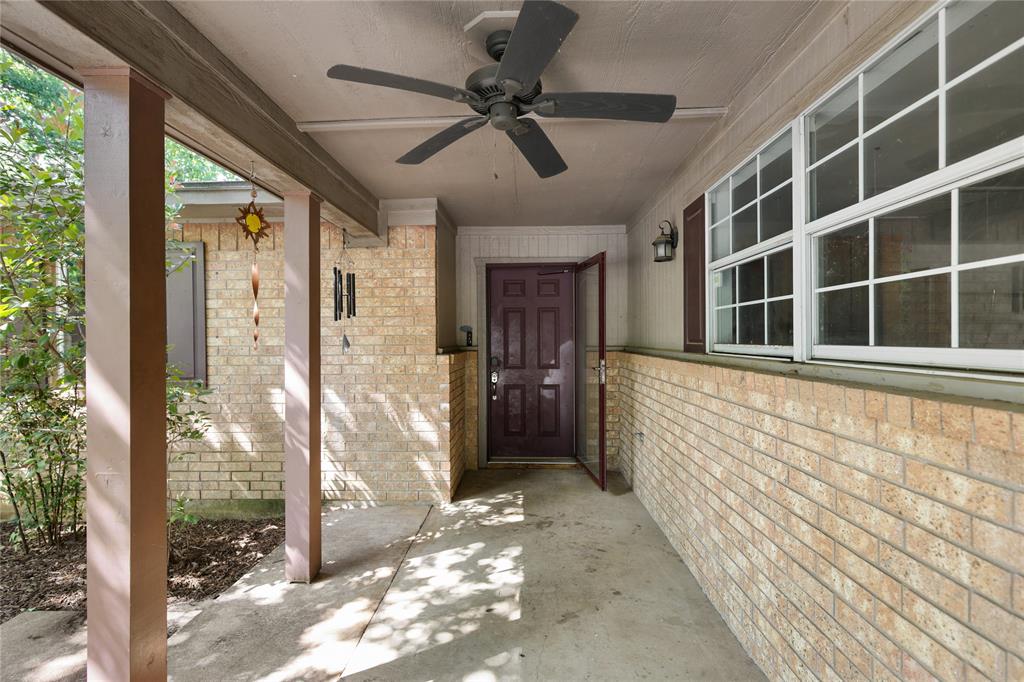 1109 Pine Ridge Drive Azle, TX 76020 - Photo 3 of 24 Inviting covered porch with a ceiling fan, brick exterior, and a dark-colored entry door