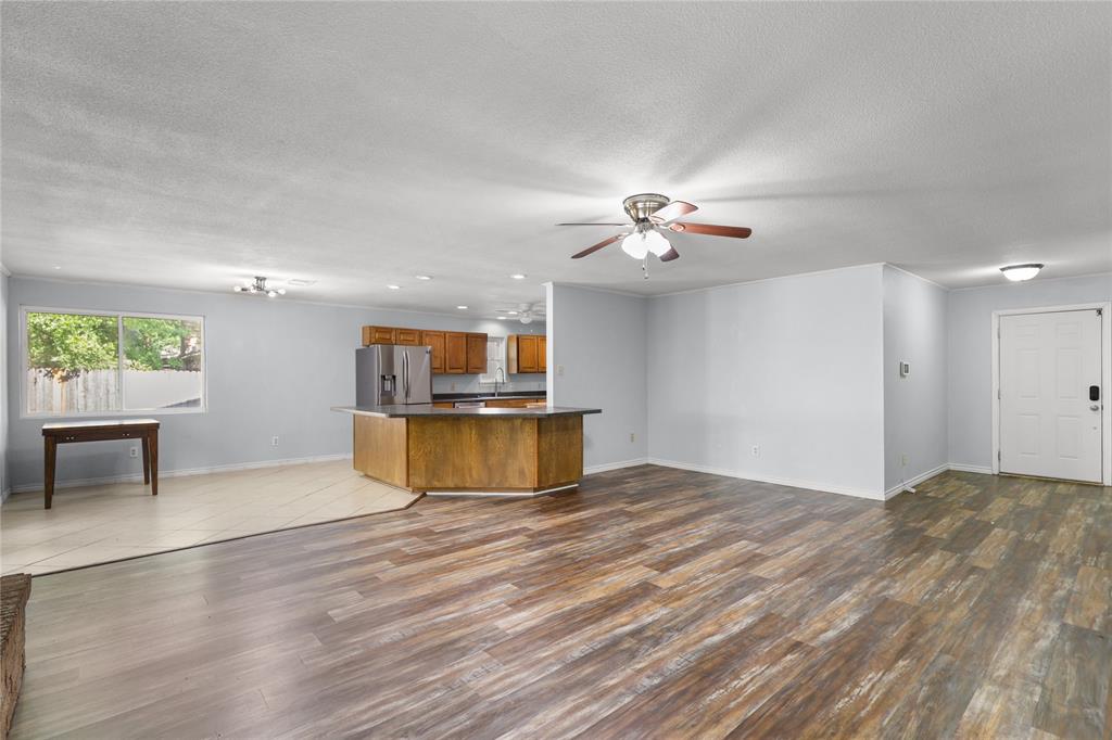 1109 Pine Ridge Drive Azle, TX 76020 - Photo 9 of 24 This open-concept interior features wood-look flooring, light-colored walls, and a ceiling fan