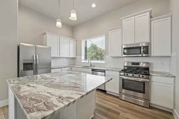 a kitchen with a stove a sink and a microwave