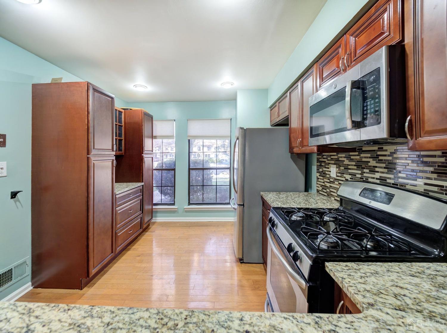 3802 Cricket Circle Edison, NJ 08820 - Photo 7 of 26 a kitchen with stainless steel appliances granite countertop a stove a refrigerator and a microwave
