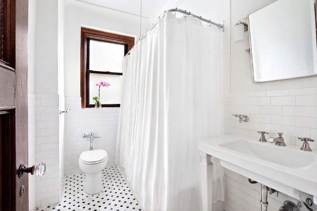 790 Riverside Drive, Unit 1J Manhattan, NY 10032 - Photo 7 of 22 a bathroom with a sink a toilet and shower