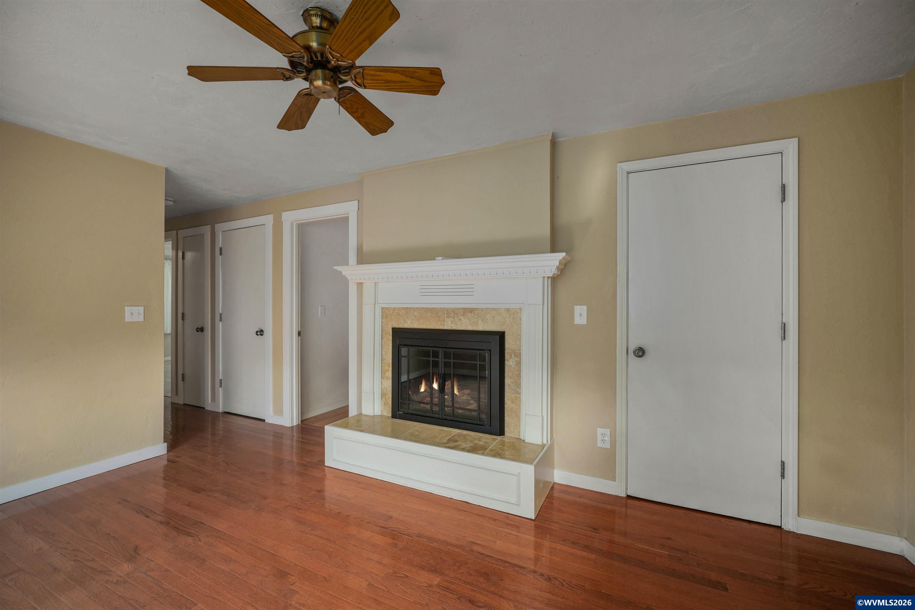 220 Northwest Downy Drive Sublimity, OR 97385 - Photo 13 of 47 a view of an empty room with wooden floor a fireplace and a window