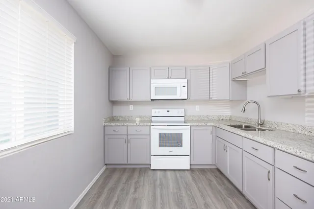 a kitchen with stainless steel appliances granite countertop white cabinets stove a sink and dishwasher