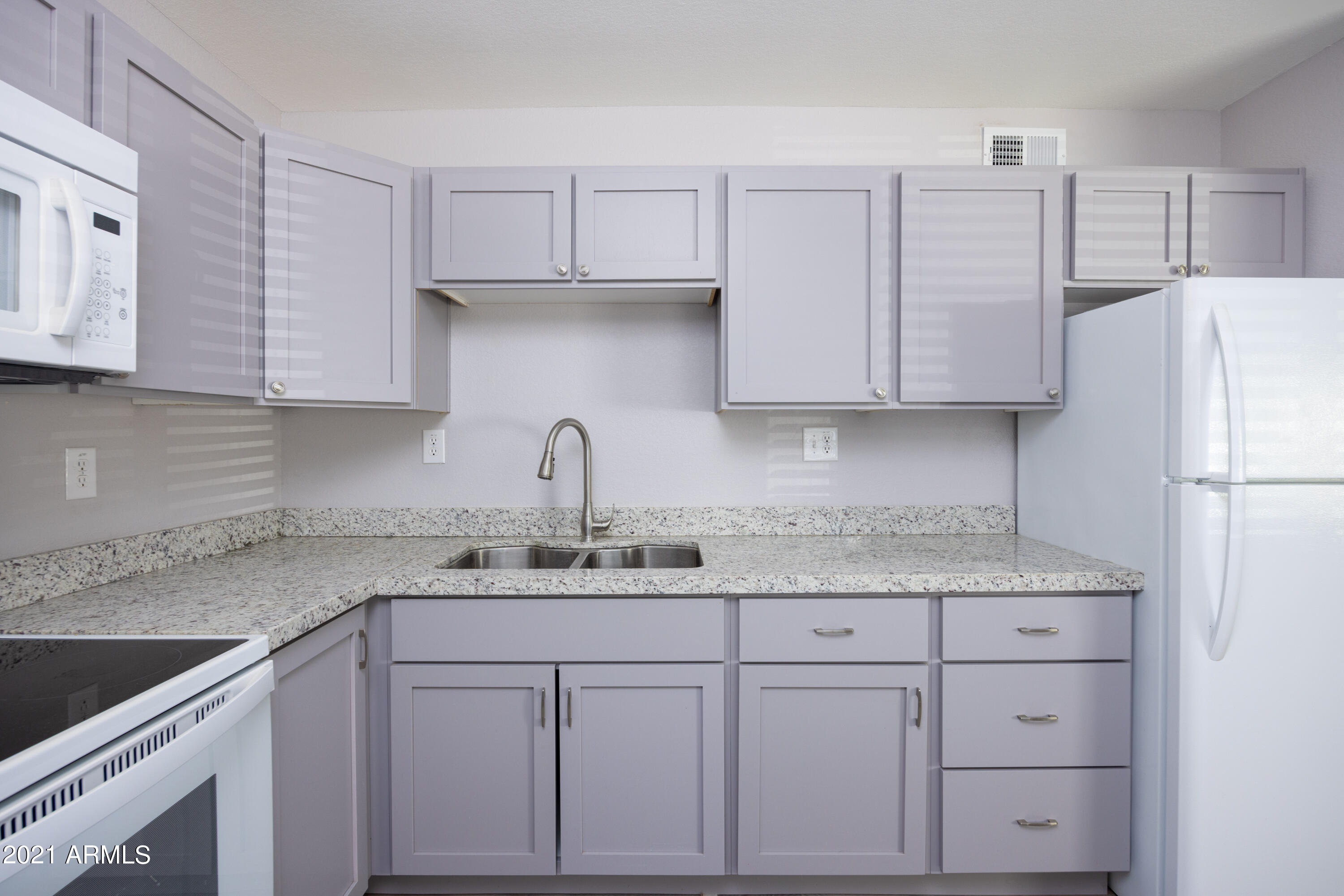 15605 North 29th Street, Unit 12 Phoenix, AZ 85032 - Photo 11 of 25 a kitchen with white cabinets and a refrigerator
