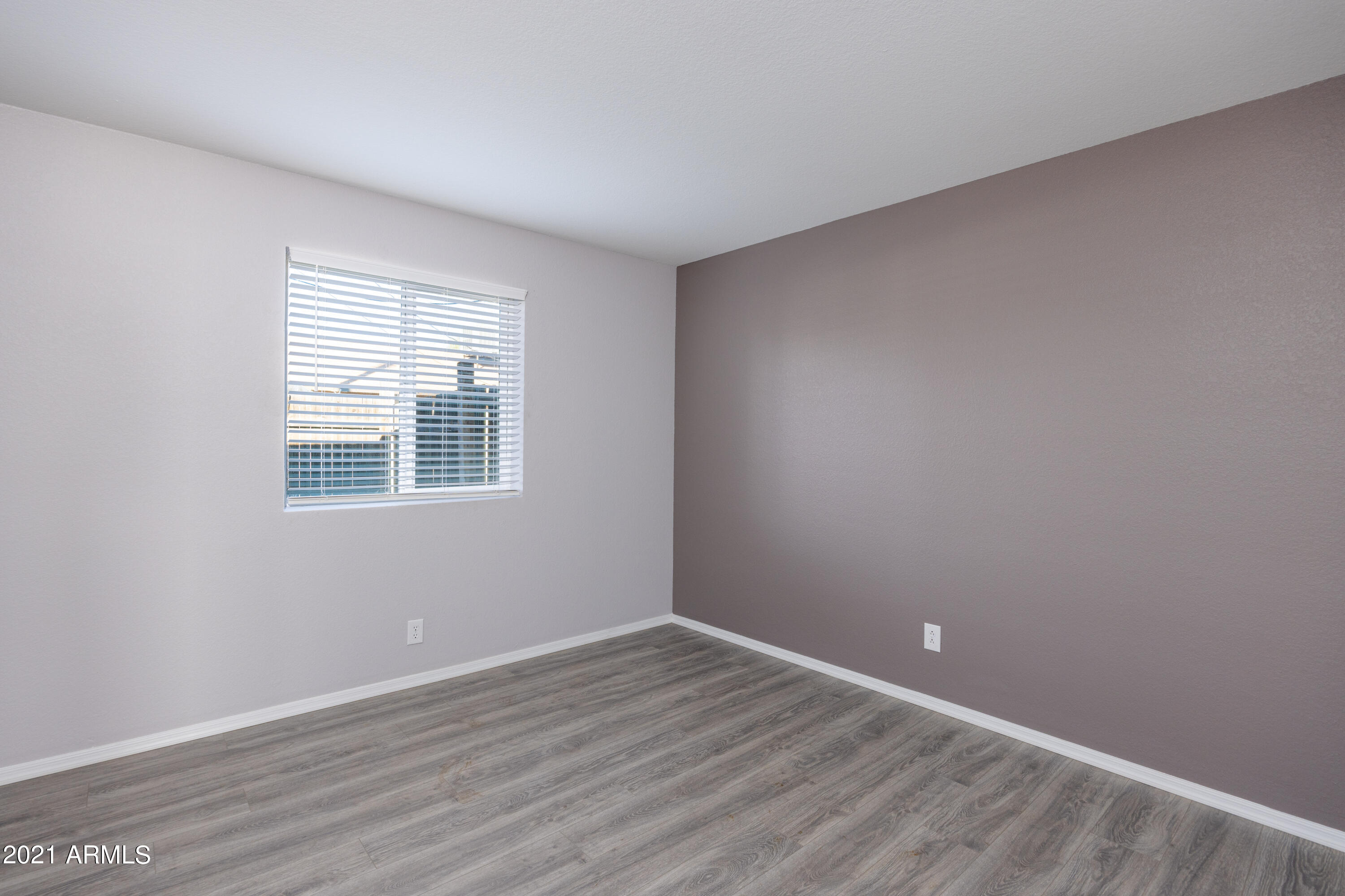 15605 North 29th Street, Unit 12 Phoenix, AZ 85032 - Photo 14 of 25 a view of an empty room with wooden floor and a window