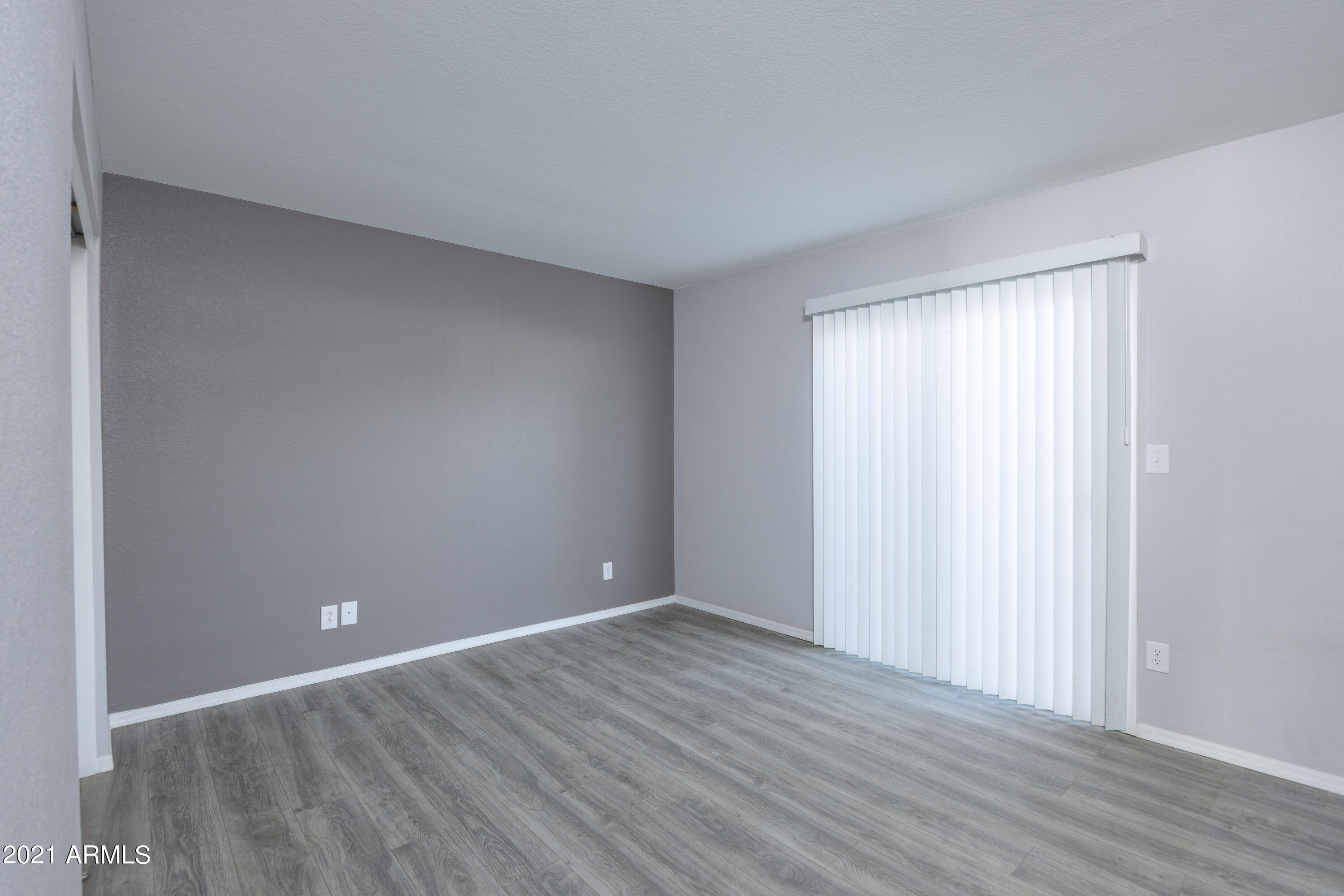 15605 North 29th Street, Unit 12 Phoenix, AZ 85032 - Photo 16 of 25 a view of an empty room with wooden floor and a window