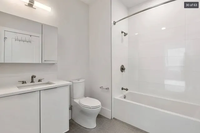 a white toilet sitting next to a bath tub
