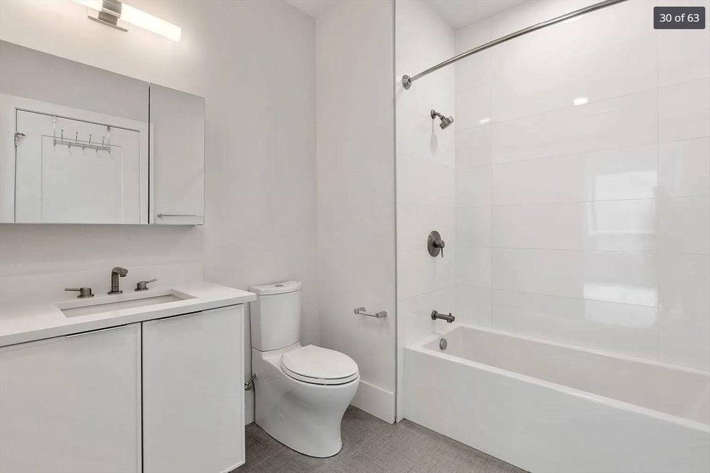 3193 Washington Street, Unit 410 Boston, MA 02130 - Photo 5 of 13 a white toilet sitting next to a bath tub
