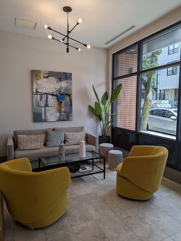 3193 Washington Street, Unit 410 Boston, MA 02130 - Photo 10 of 13 a living room with furniture potted plant and a large window
