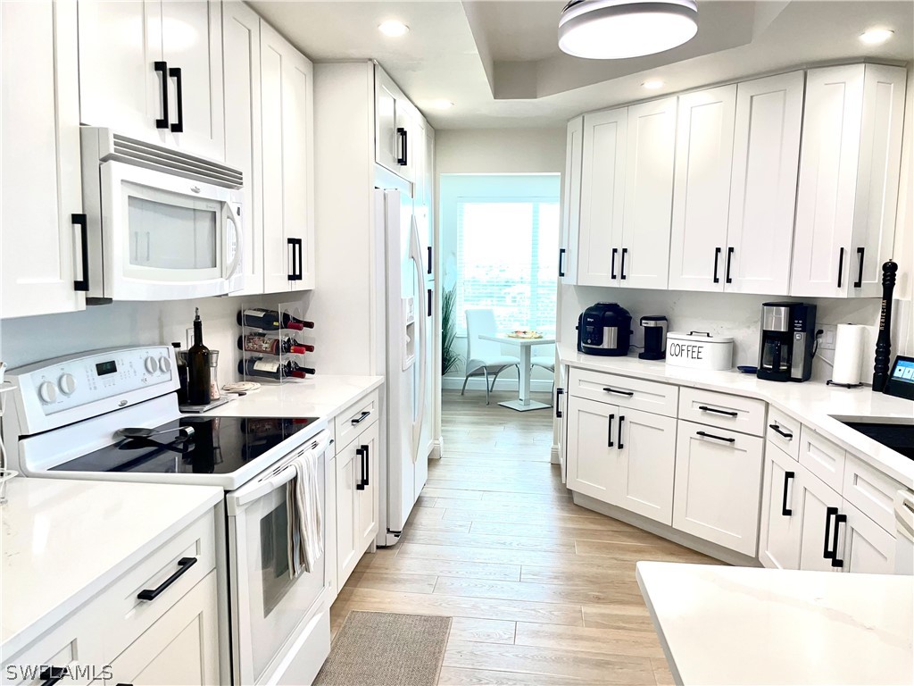 a kitchen with white cabinets sink and white appliances