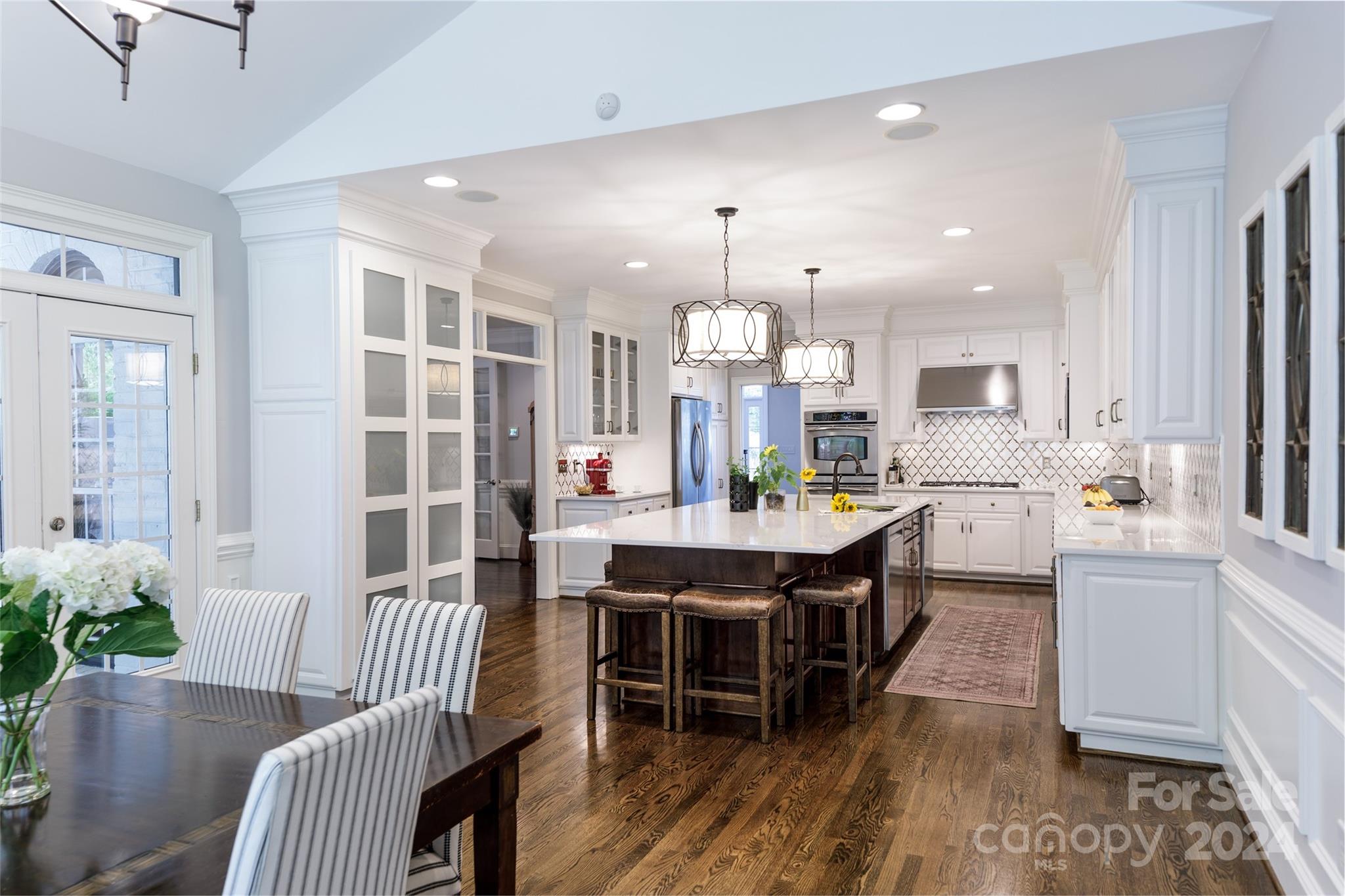 1201 Lost Oak Road Charlotte, NC 28270 - Photo 15 of 46 a large kitchen with kitchen island a large island a sink a stove and a chandelier