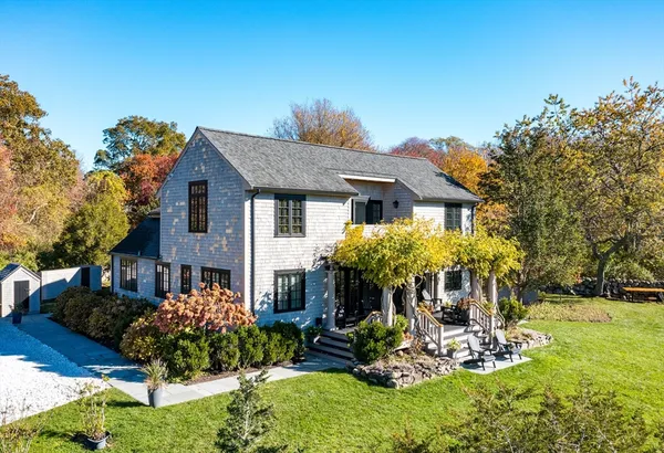a front view of a house with a yard and outdoor seating