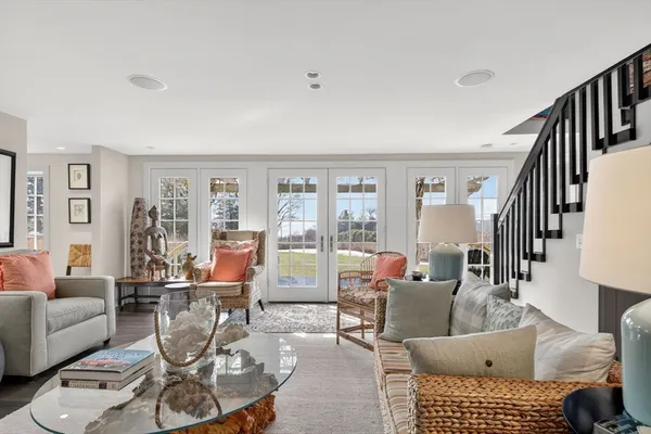 a living room with furniture a rug and a floor to ceiling window
