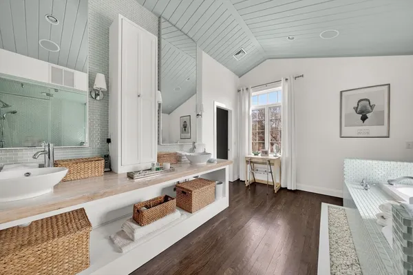 a large bathroom with double vanity sinks a large mirror and a shower