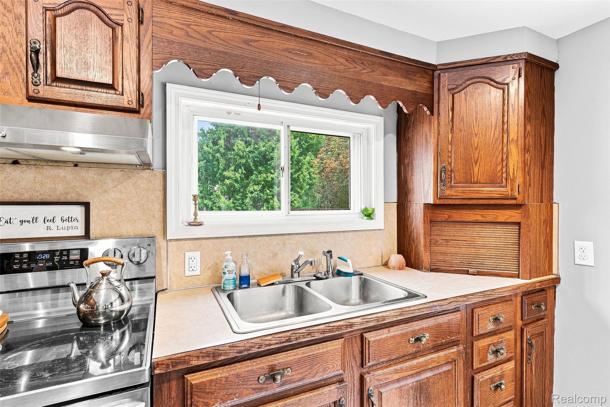 3319 Valentine Road Lapeer, MI 48446 - Photo 16 of 39 Wood-finish cabinetry, stainless steel double basin sink, and a built-in range hood