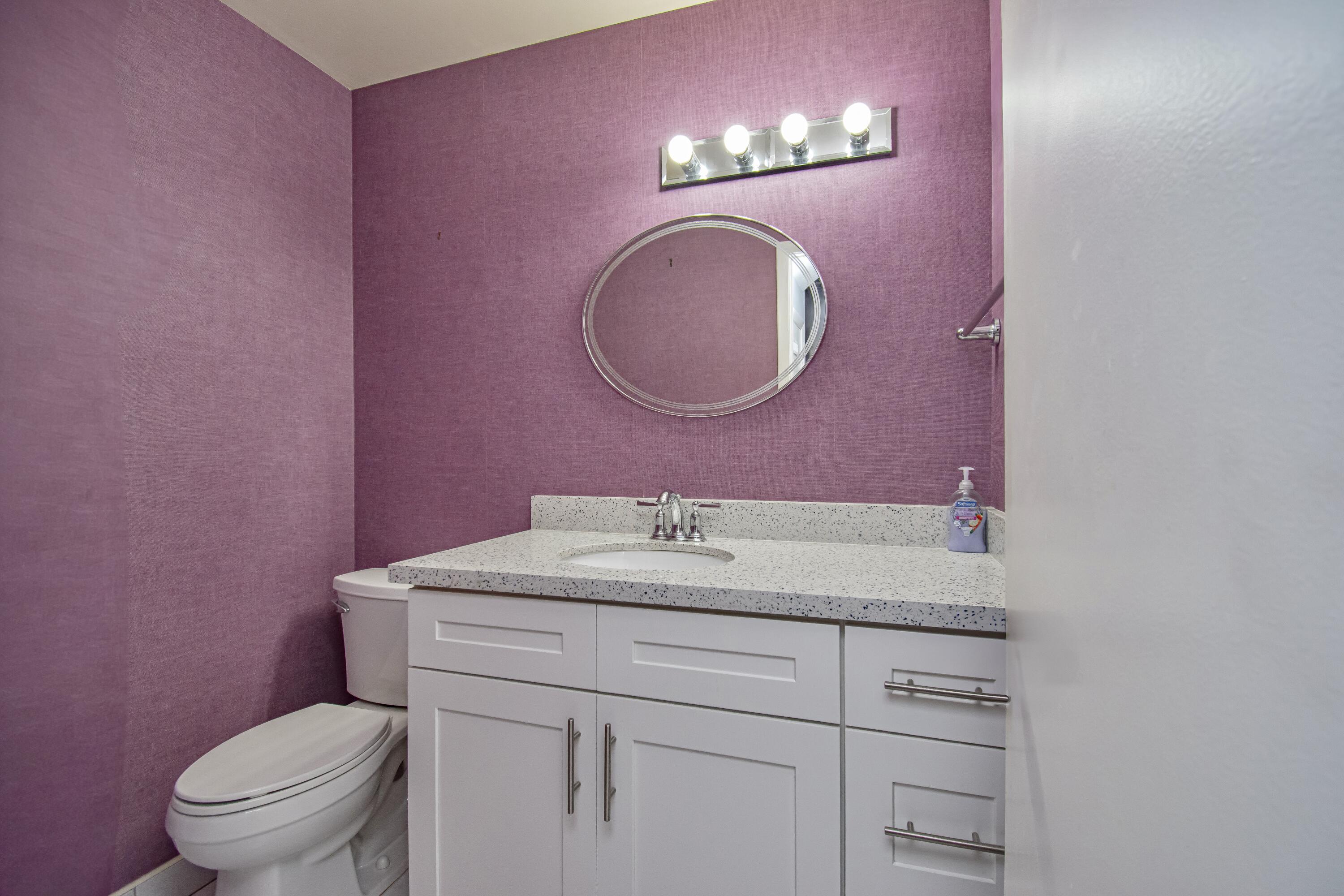 9460 Southwest 61st Way, Unit B Boca Raton, FL 33428 - Photo 15 of 31 a bathroom with a toilet sink vanity and mirror