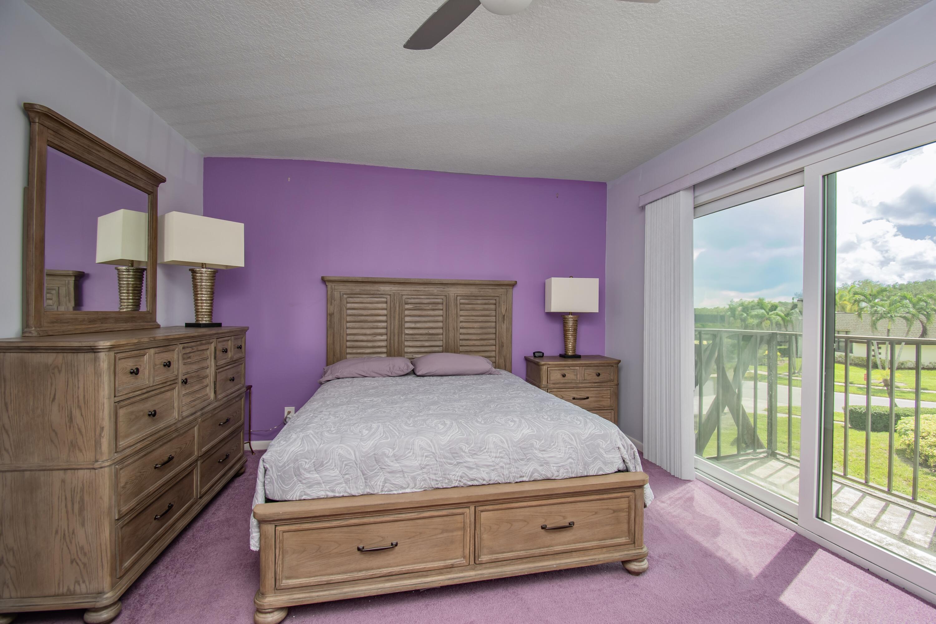 9460 Southwest 61st Way, Unit B Boca Raton, FL 33428 - Photo 22 of 31 a bedroom with a bed and large windows