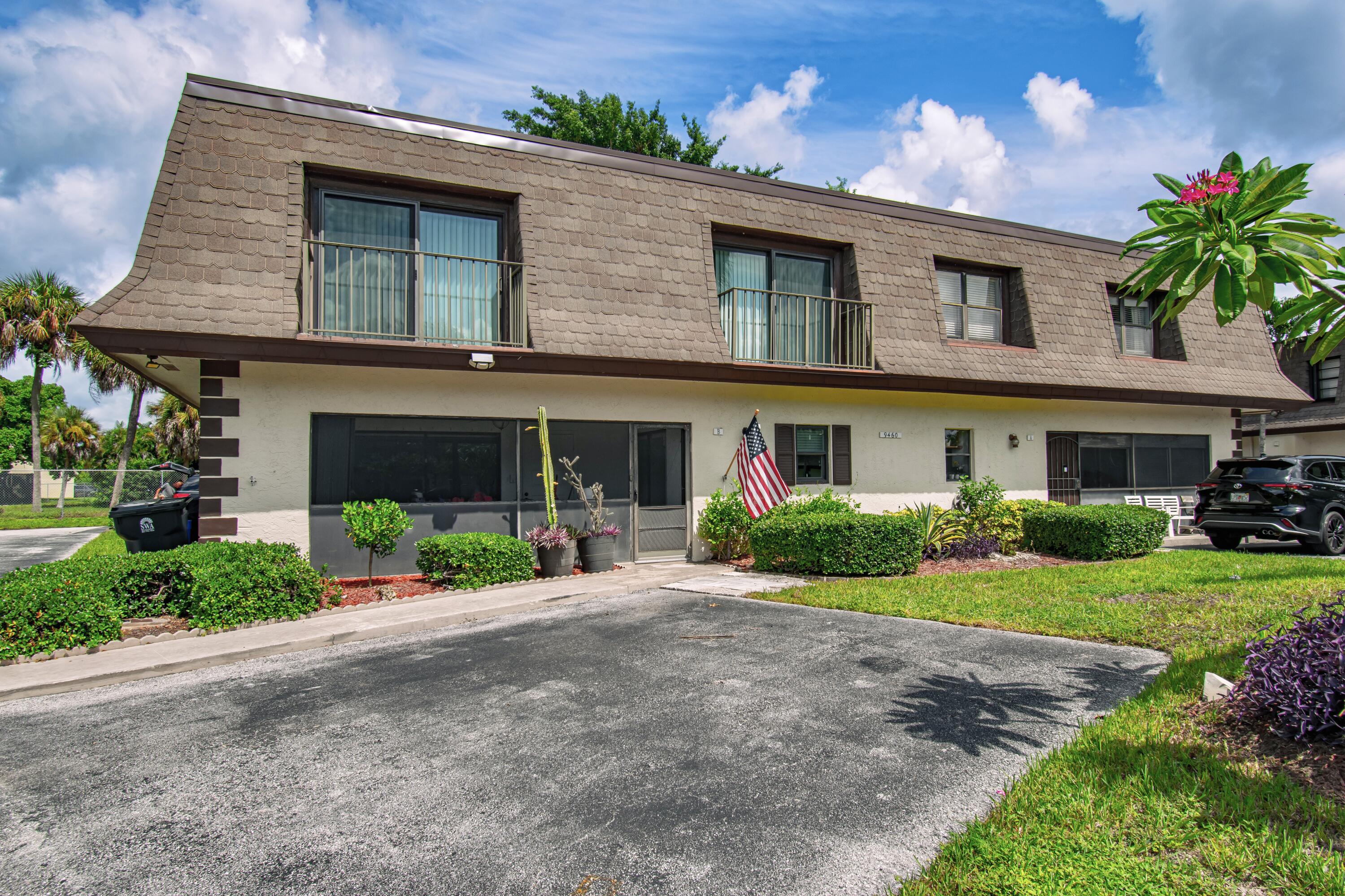 9460 Southwest 61st Way, Unit B Boca Raton, FL 33428 - Photo 3 of 31 a front view of a house with a garden and potted plants