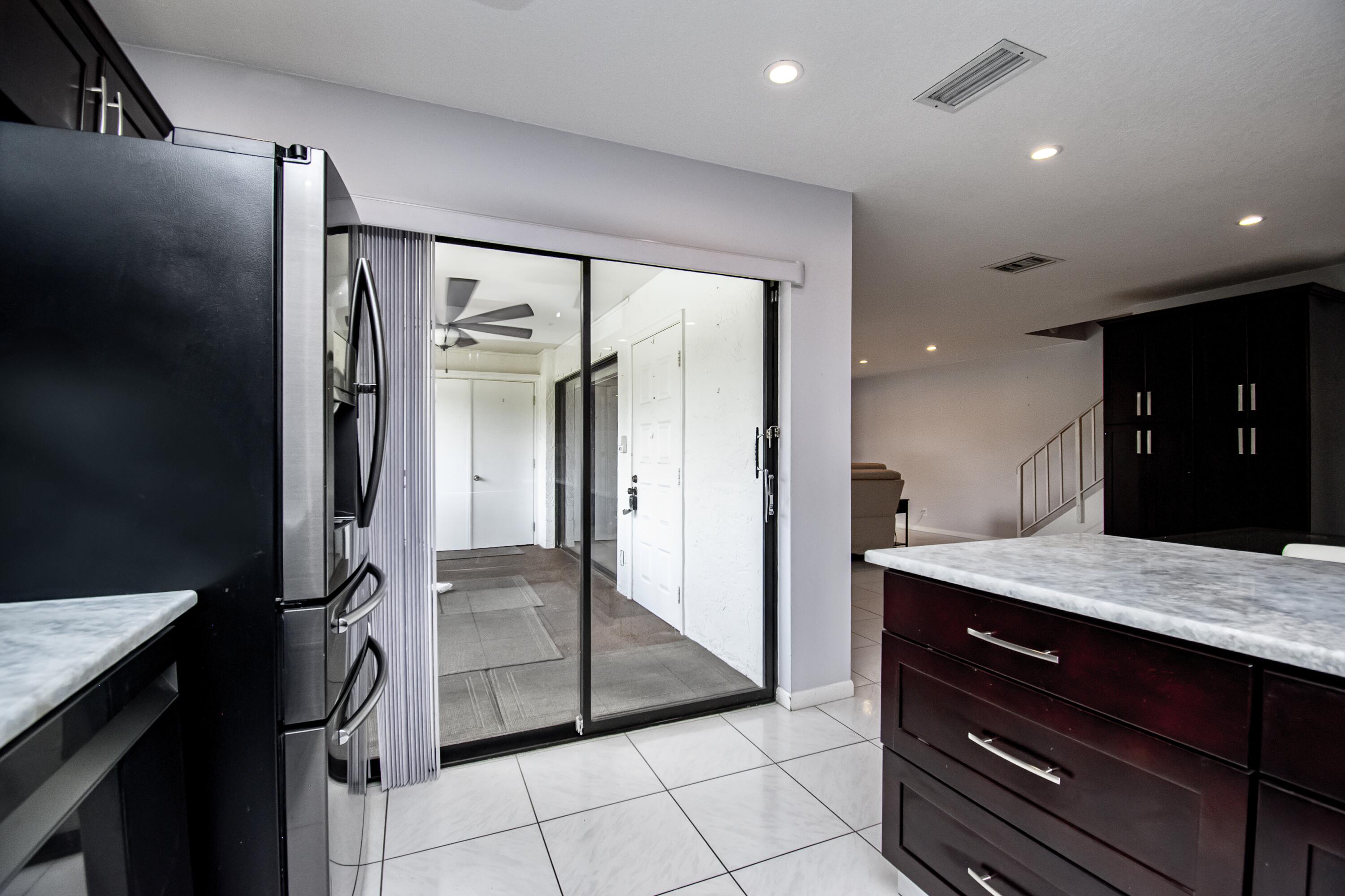 9460 Southwest 61st Way, Unit B Boca Raton, FL 33428 - Photo 8 of 31 a kitchen with a refrigerator and a sink
