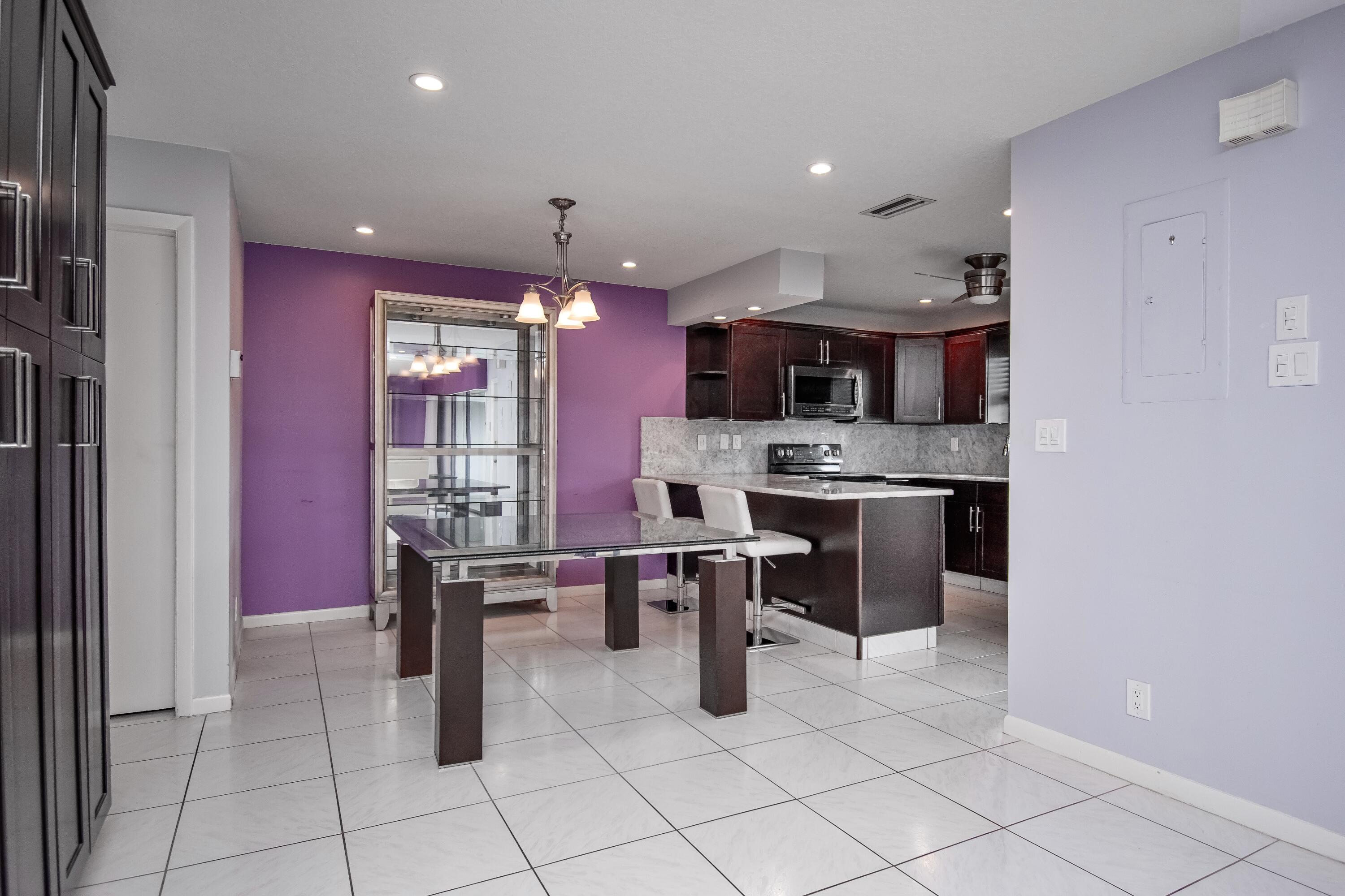 9460 Southwest 61st Way, Unit B Boca Raton, FL 33428 - Photo 10 of 31 a kitchen with stainless steel appliances kitchen island granite countertop a refrigerator and a stove top oven