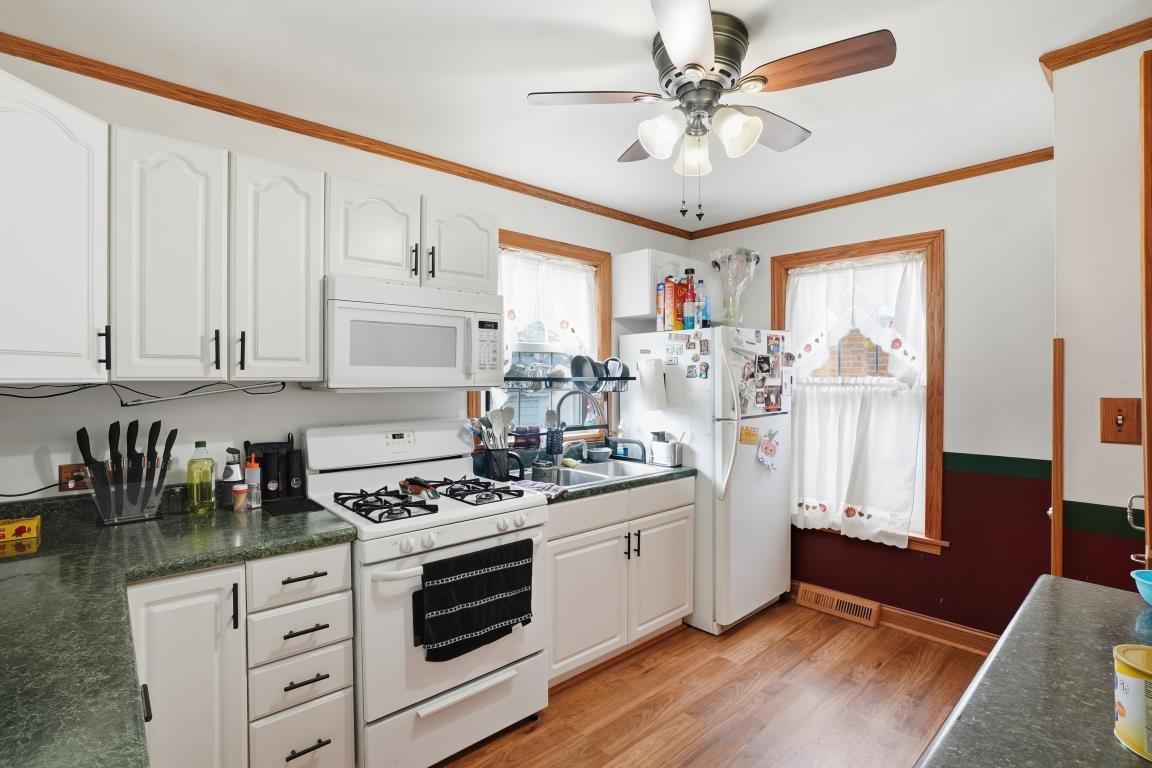 4240 Custer Avenue Brookfield, IL 60513 - Photo 15 of 28 a kitchen with stainless steel appliances granite countertop a stove a sink dishwasher and white cabinets with wooden floor