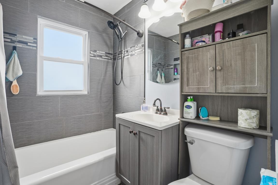 4240 Custer Avenue Brookfield, IL 60513 - Photo 9 of 28 a bathroom with a sink a vanity and a bathtub