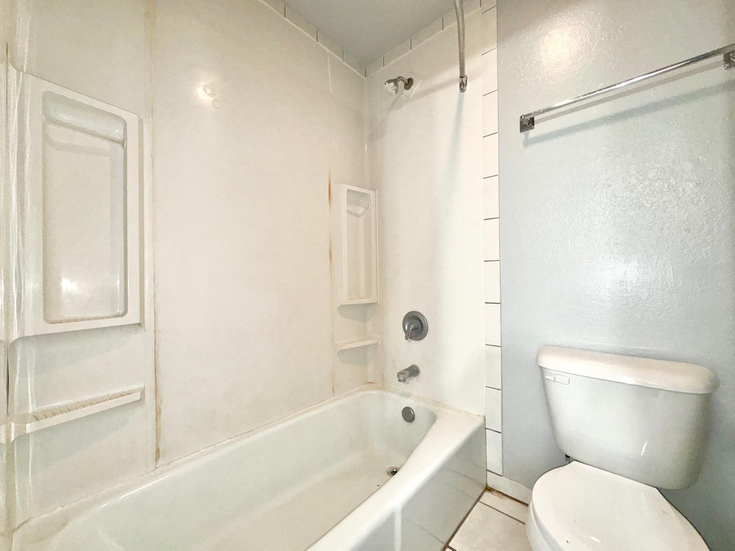 5763 38th Street Lubbock, TX 79407 - Photo 11 of 16 a bathroom with a toilet and a bathtub