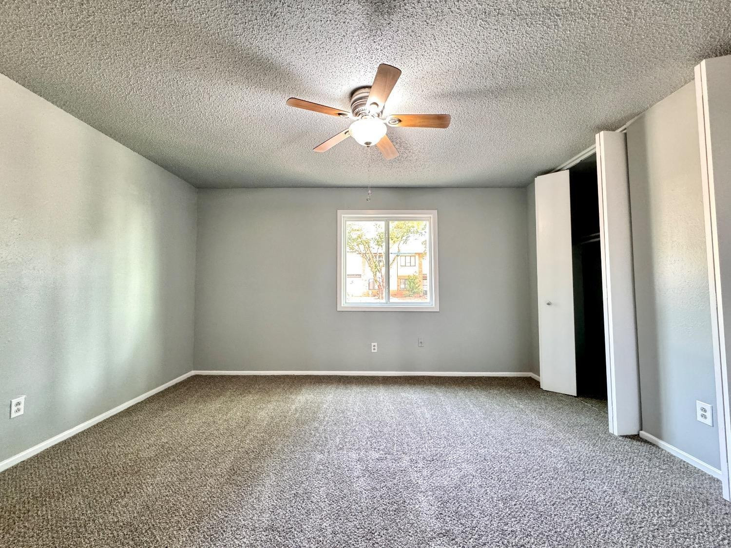 5763 38th Street Lubbock, TX 79407 - Photo 12 of 16 an empty room with chandelier fan and windows