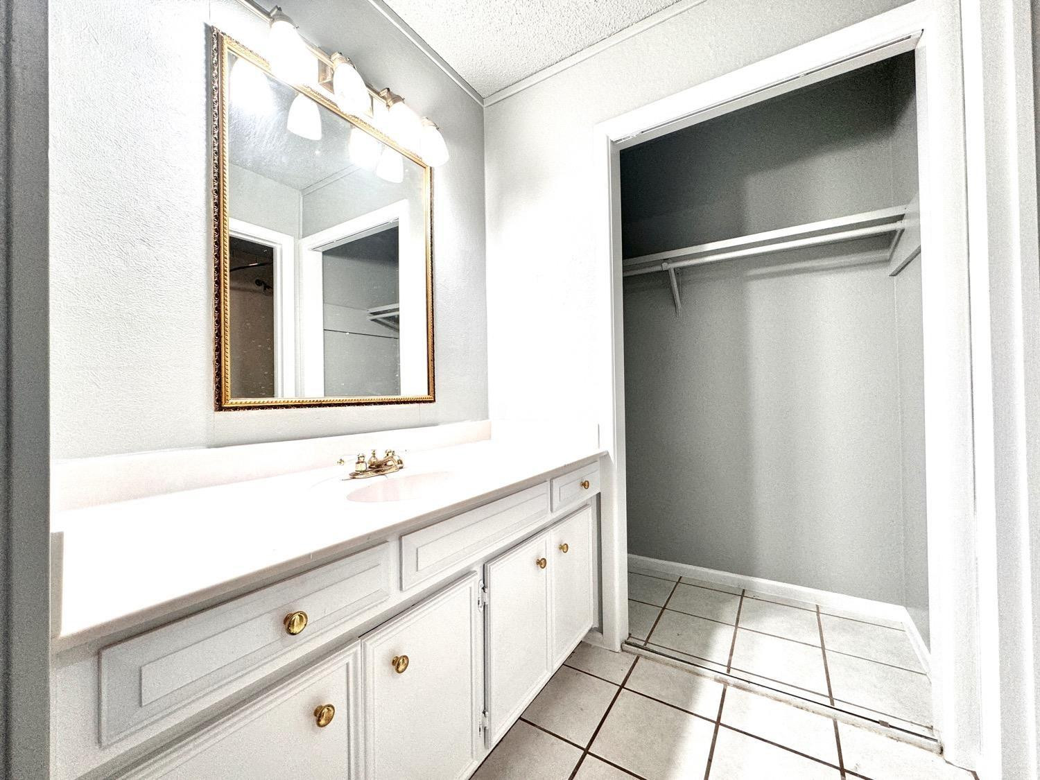 5763 38th Street Lubbock, TX 79407 - Photo 13 of 16 a bathroom with a sink and a mirror