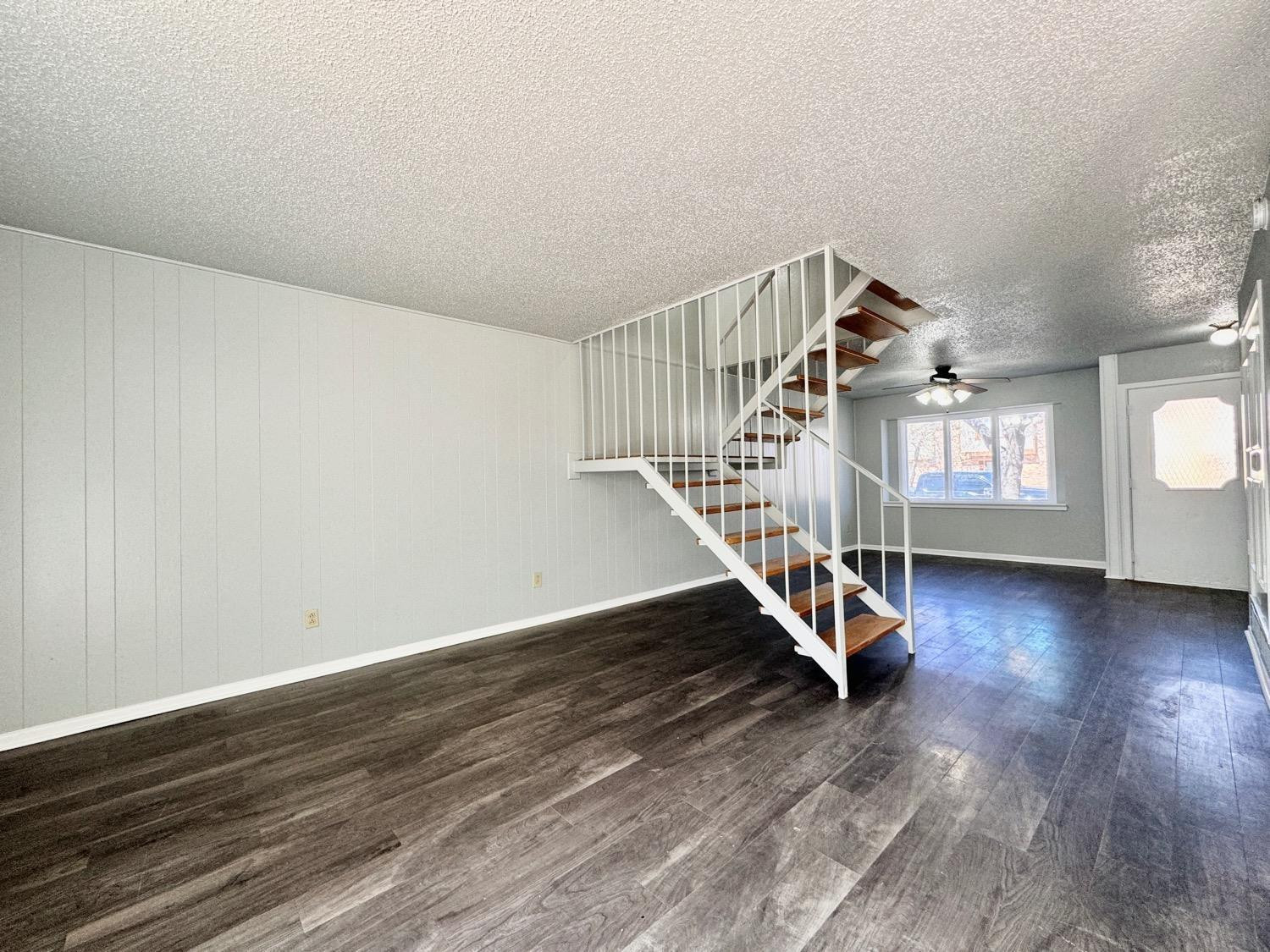 5763 38th Street Lubbock, TX 79407 - Photo 3 of 16 a view of staircase with white walls and wooden floor