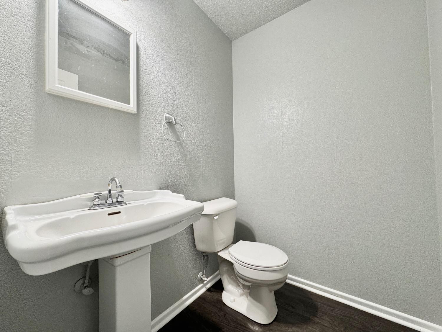 5763 38th Street Lubbock, TX 79407 - Photo 7 of 16 a bathroom with a sink a toilet and mirror