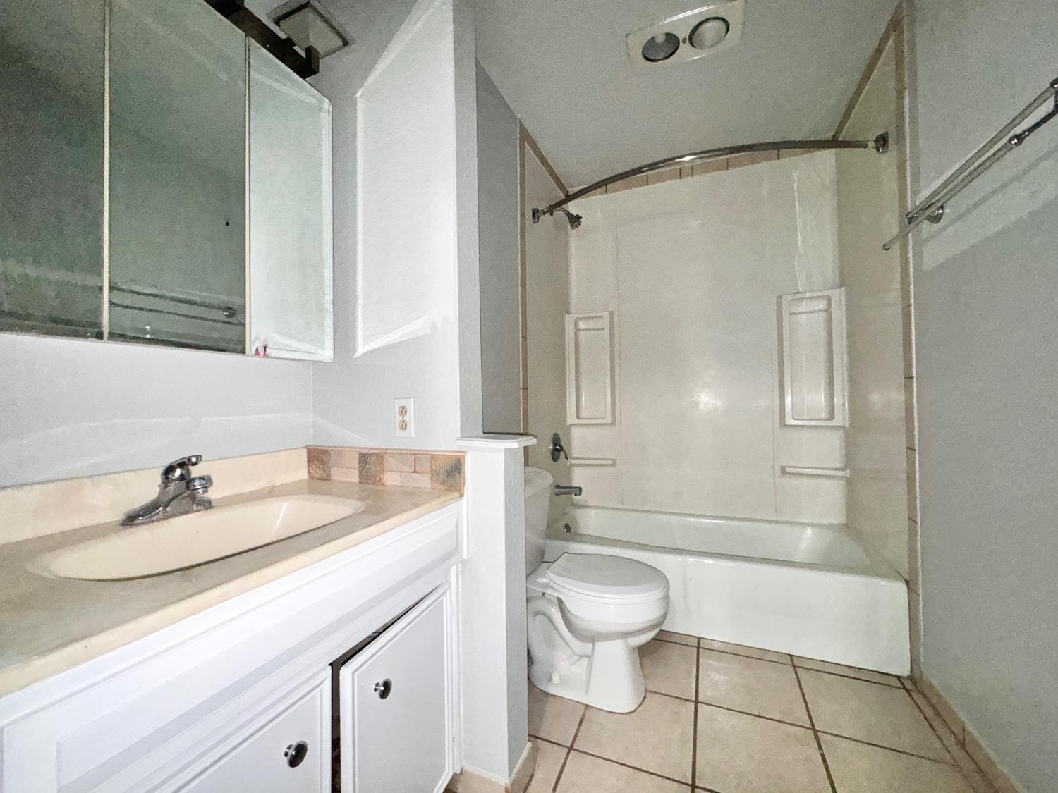 5763 38th Street Lubbock, TX 79407 - Photo 10 of 16 a bathroom with a sink a toilet and shower