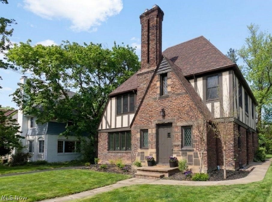3145 Huntington Road Shaker Heights, OH 44120 - Photo 2 of 28 Tudor-style exterior featuring brick and timber frame detailing, a prominent brick chimney, diamond-pane windows, and a front entry with stone steps