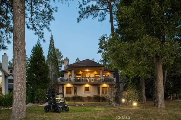 a view of a big house with a big yard and large trees
