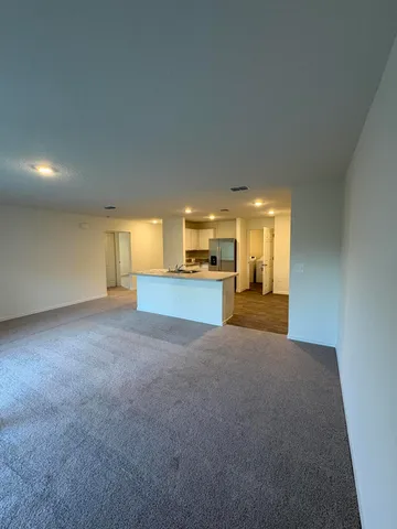 a view of empty room with a kitchen