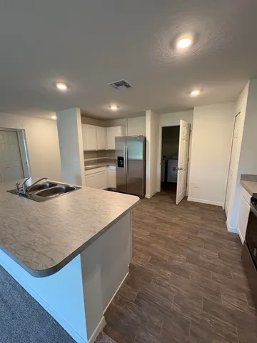 a view of kitchen with refrigerator microwave and wooden floor
