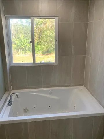 a bathroom with a bathtub and window