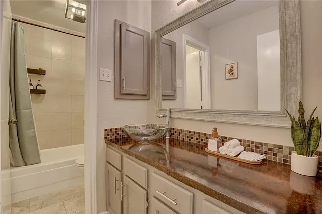 a bathroom with a granite countertop sink and a mirror