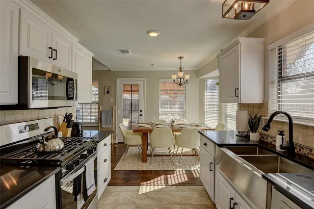 a kitchen with lots of counter top space appliances and windows
