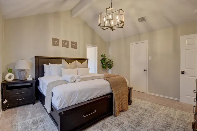 a bedroom with a bed and a chandelier