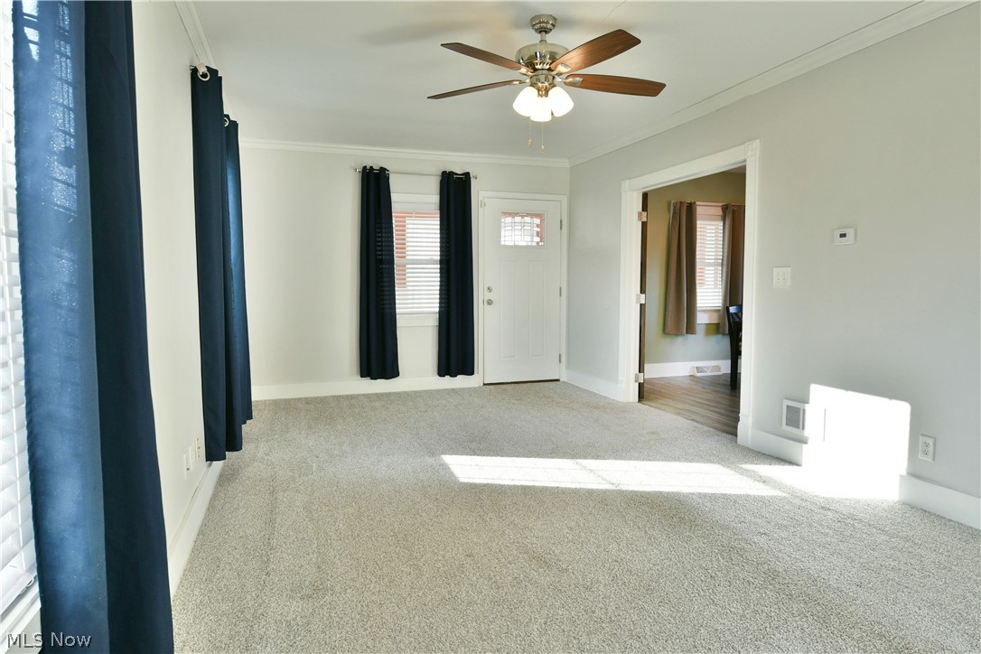 1525 Elm Road Northeast Warren, OH 44483 - Photo 16 of 50 Empty room with light colored carpet, crown molding, and ceiling fan