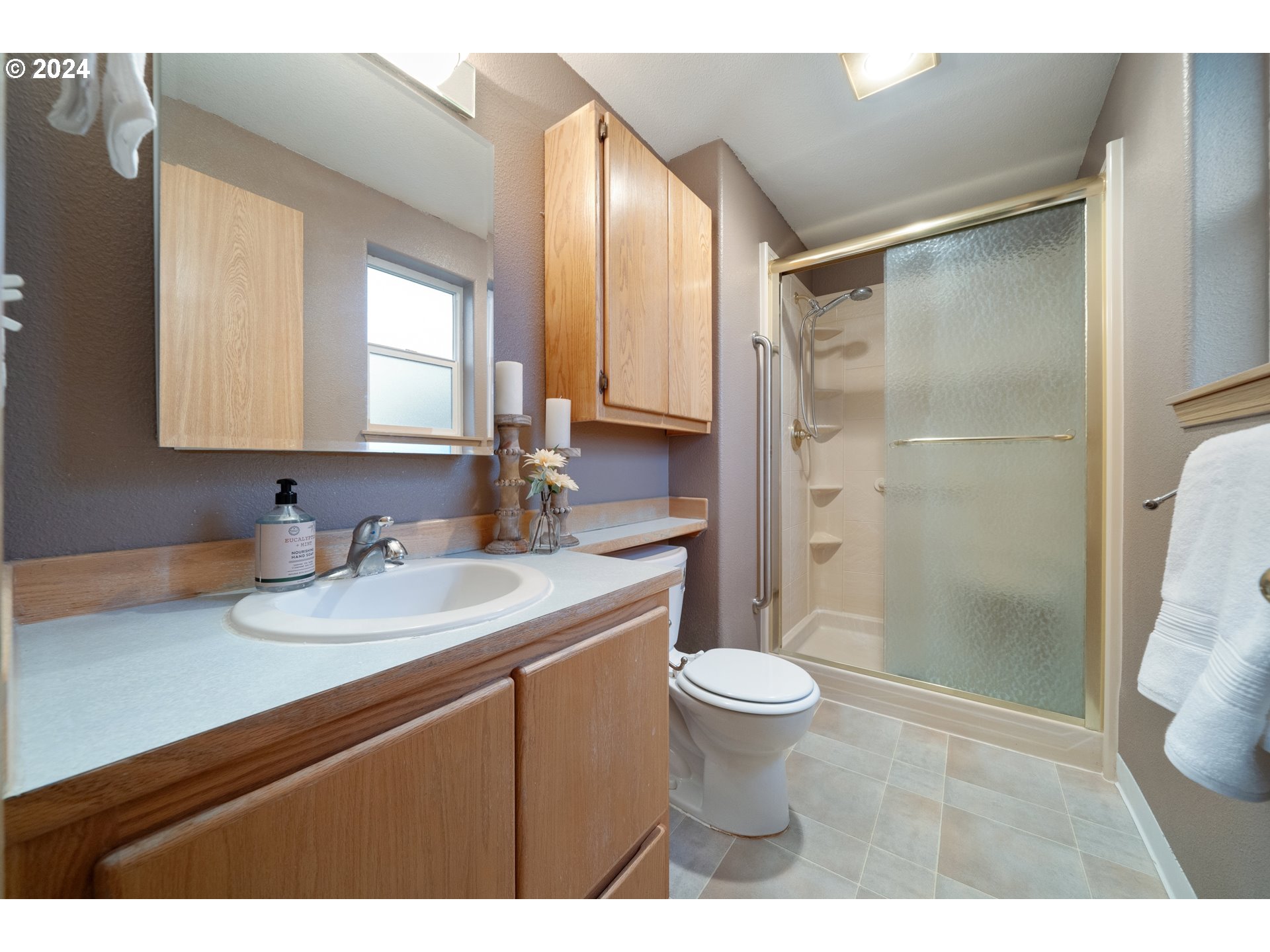 13509 Northeast 77th Street Vancouver, WA 98682 - Photo 26 of 29 a bathroom with a sink a toilet a mirror and shower