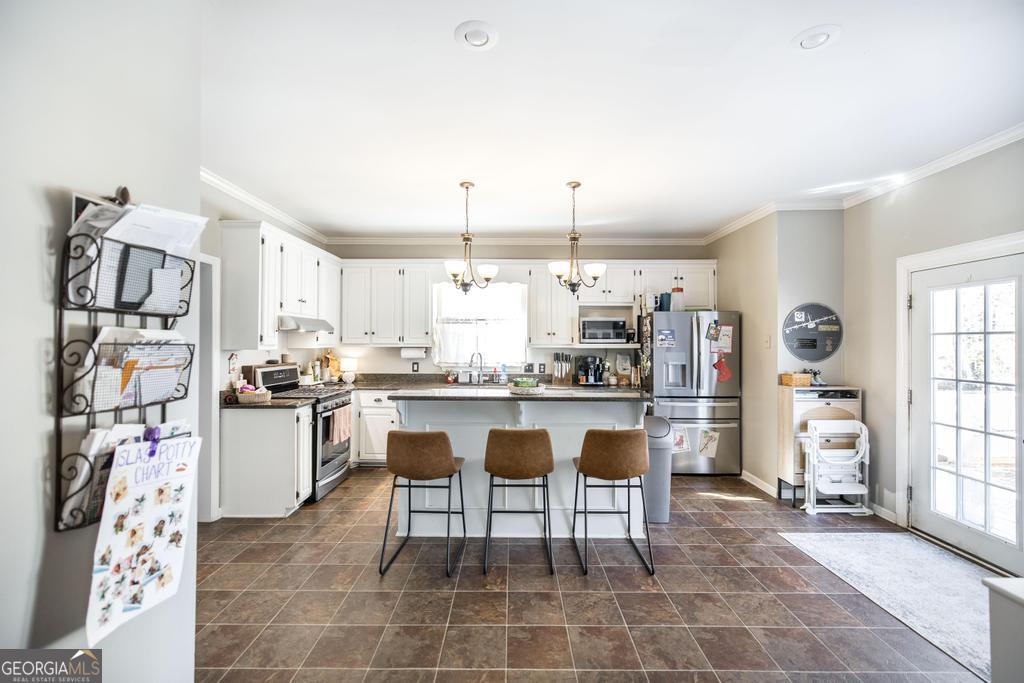 128 Springwood Court Macon, GA 31210 - Photo 5 of 22 a kitchen with a sink and chairs