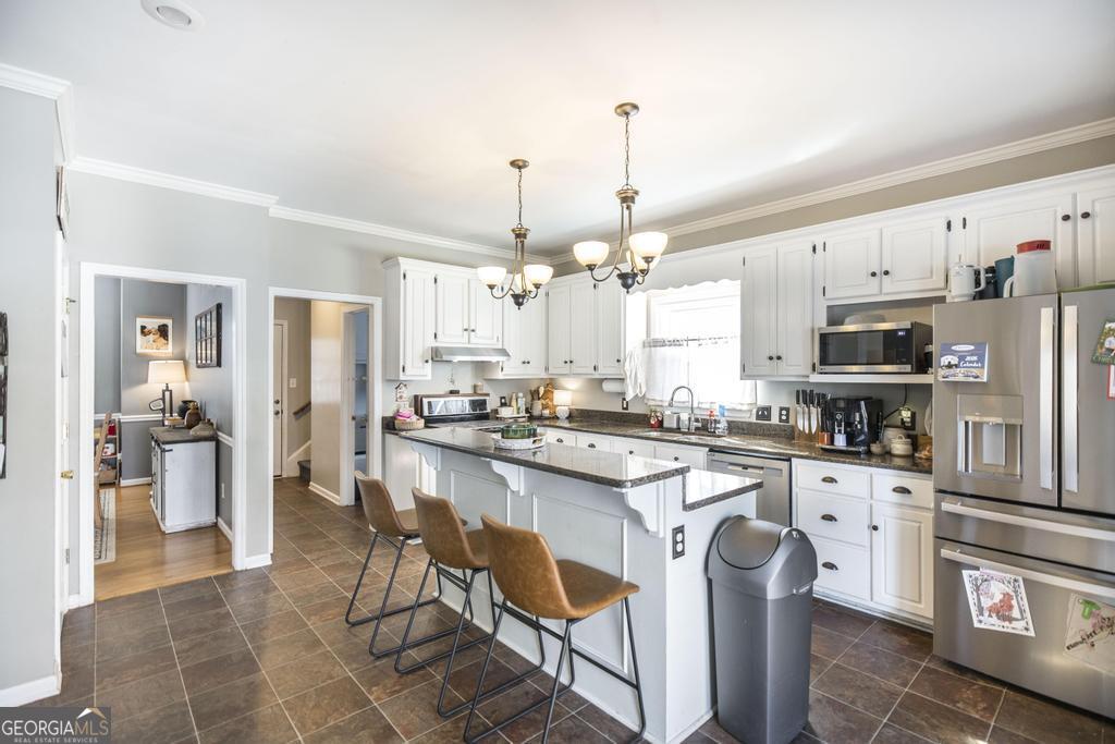 128 Springwood Court Macon, GA 31210 - Photo 6 of 22 a kitchen with stainless steel appliances kitchen island granite countertop a sink and cabinets