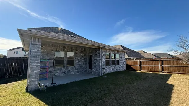 a view of a house with a large window and wooden fence