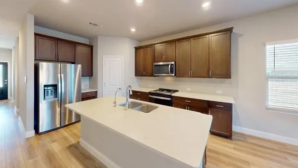 a kitchen with stainless steel appliances a refrigerator and a stove top oven